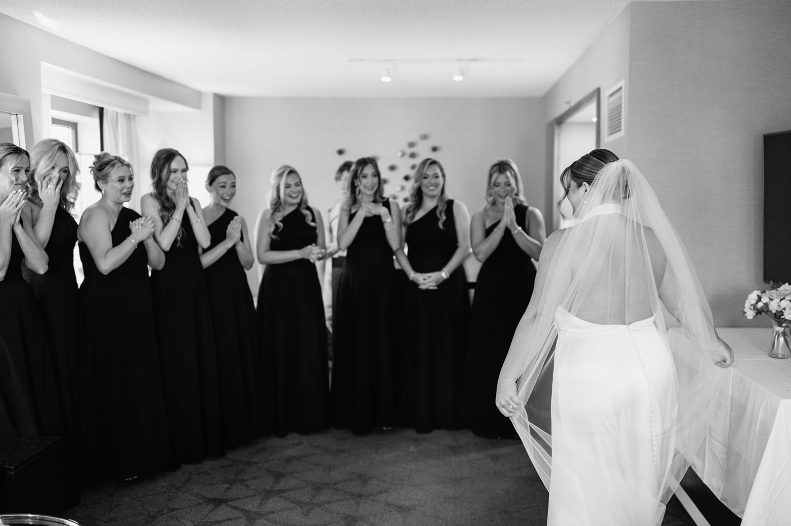 Bridesmaids reacting to seeing the bride in her wedding dress for the first time.