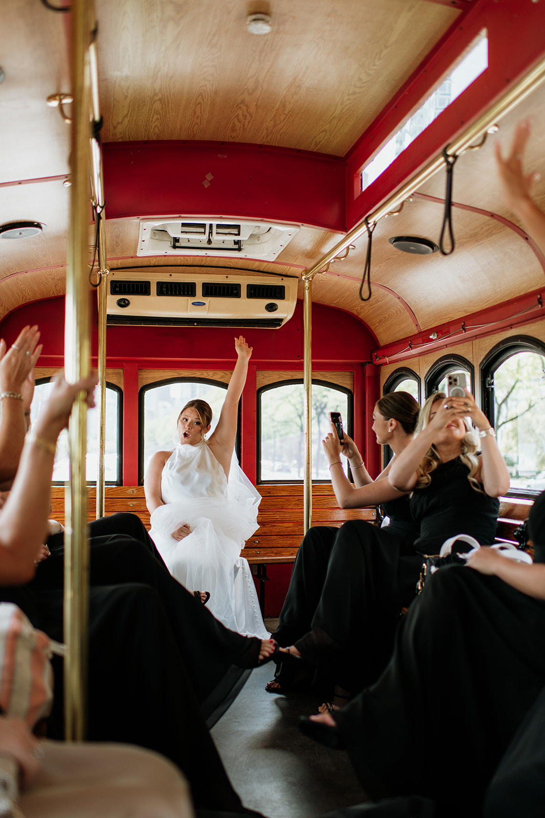 Bride celebrating with bridesmaids on a trolley before the ceremony.