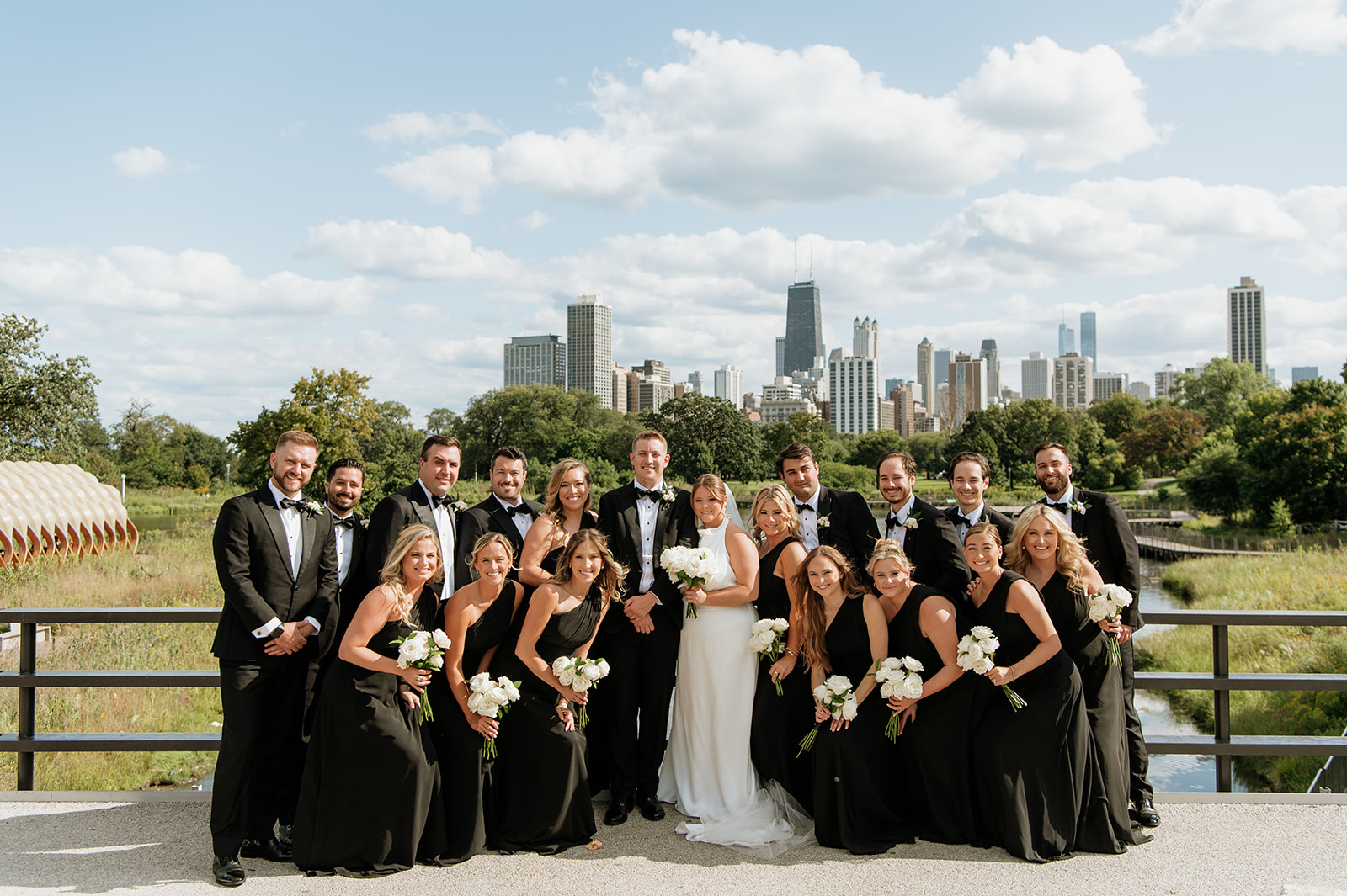 Outdoor Chicago wedding party photos at Lincoln Park South Pond with the skyline behind them.