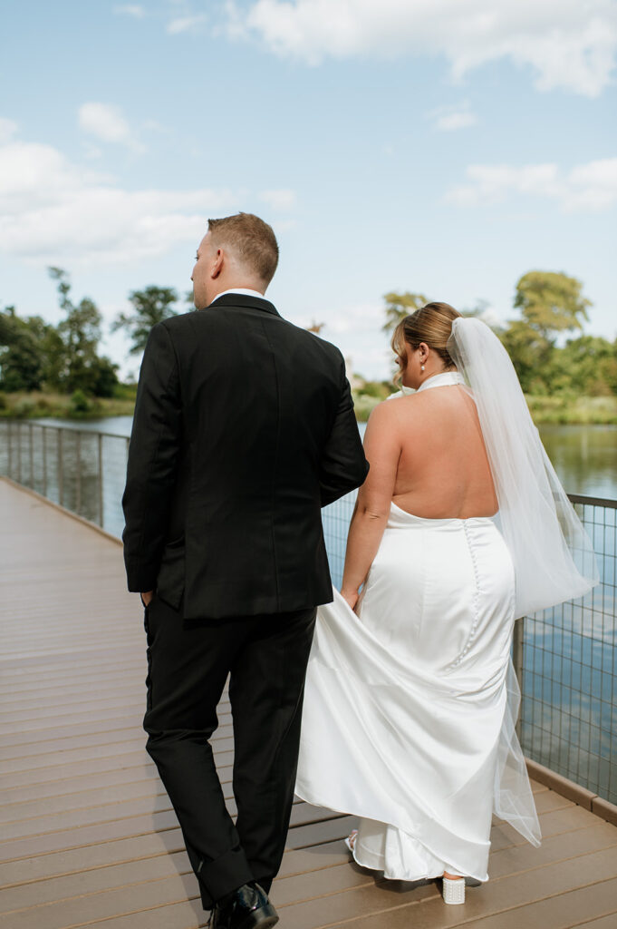 Bride and groom walking a boardwalk at Lincoln Park in Chicago.