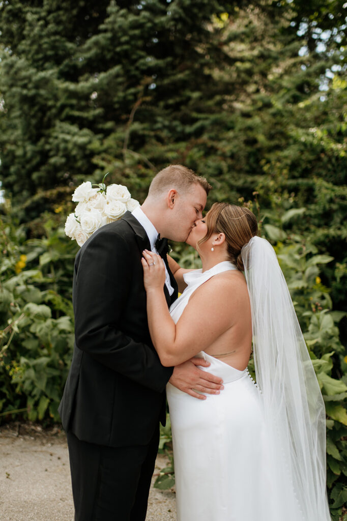 Bride and groom kissing in Lincoln Park in Chicago for their wedding portraits. 