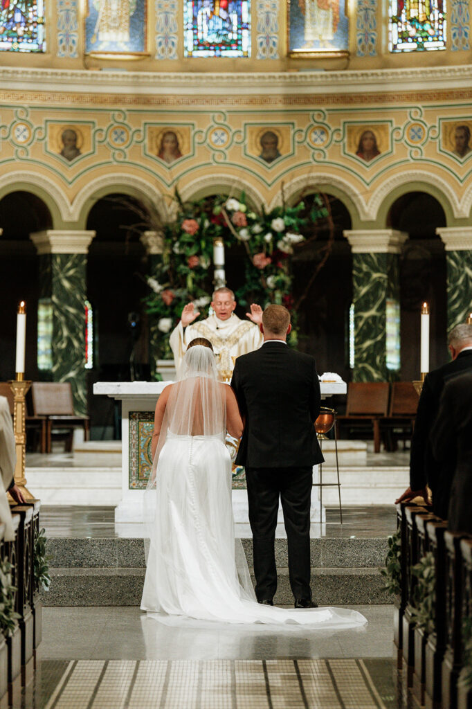 Bride and groom standing at the altar during their Saint Clement Parish wedding ceremony in Chicago.