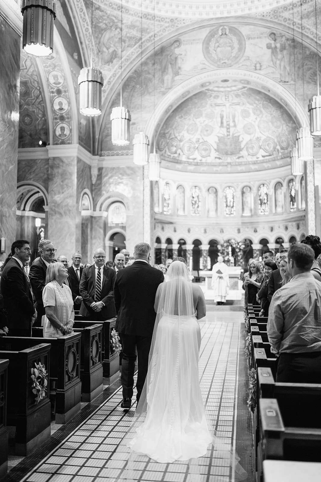 Bride walking down the aisle with her father during a Catholic wedding ceremony at Saint Clement Parish in Chicago.