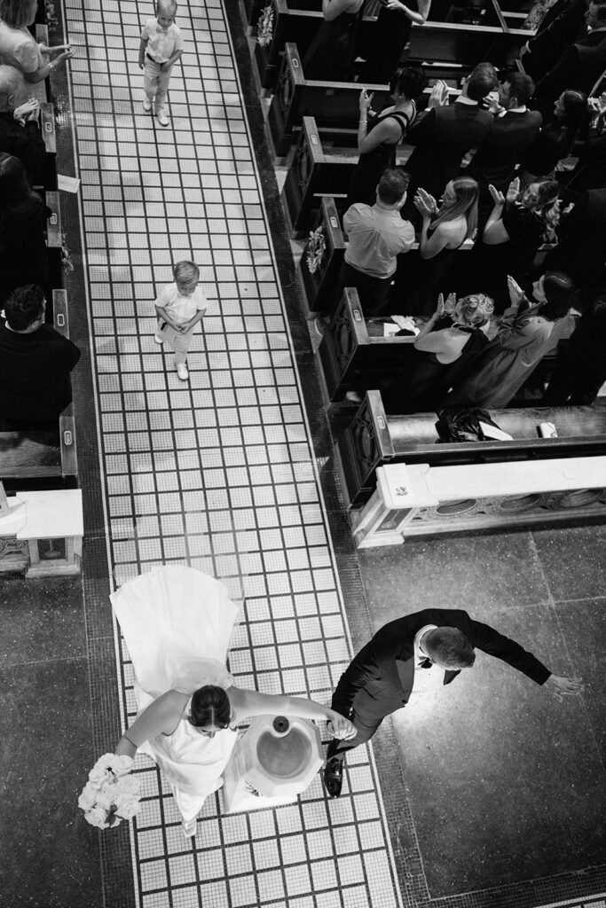 Overhead view of the newlyweds walking down the aisle after their Catholic wedding ceremony.