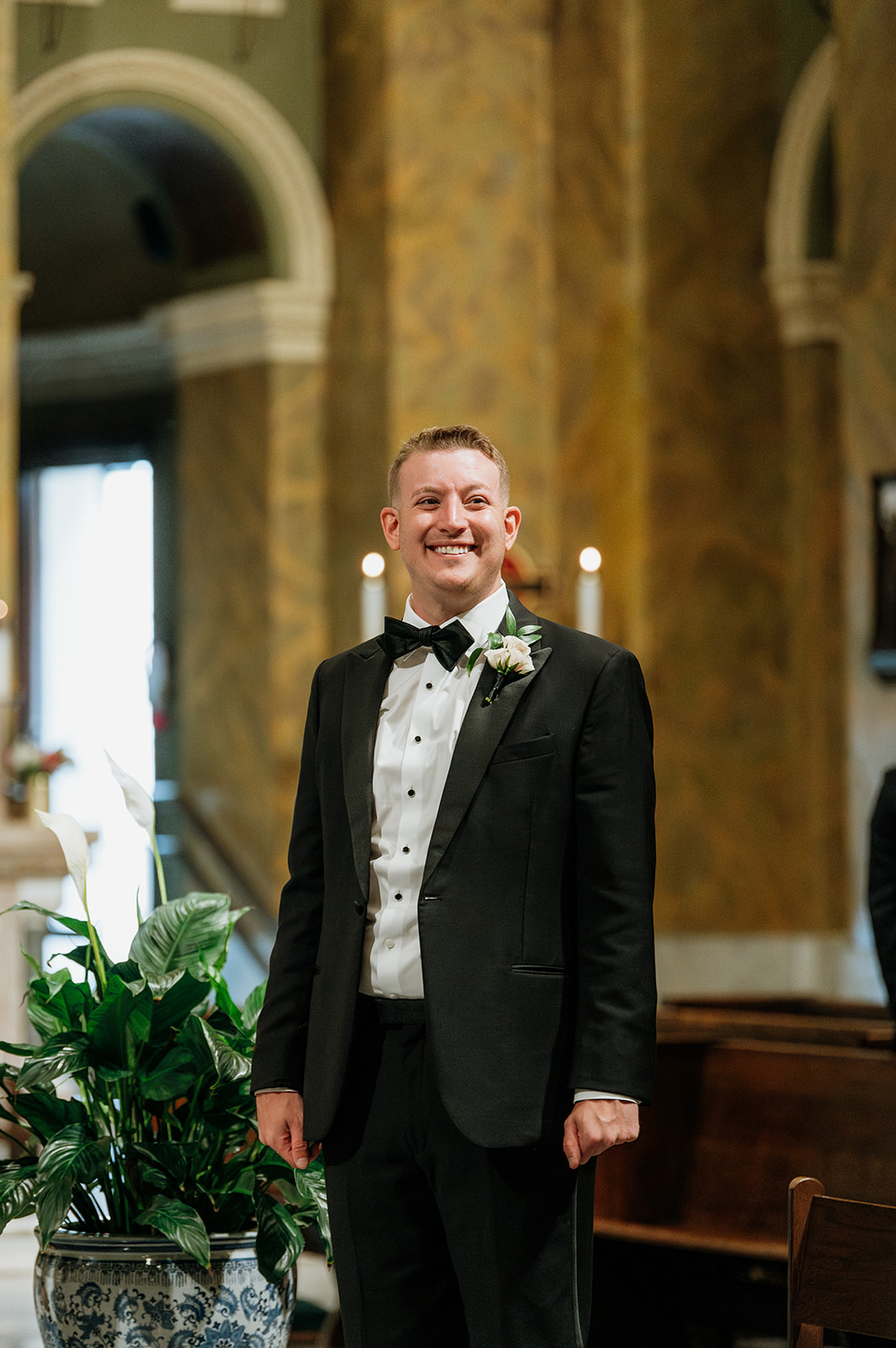 Groom smiling at the altar inside Saint Clement Parish before the ceremony begins.
