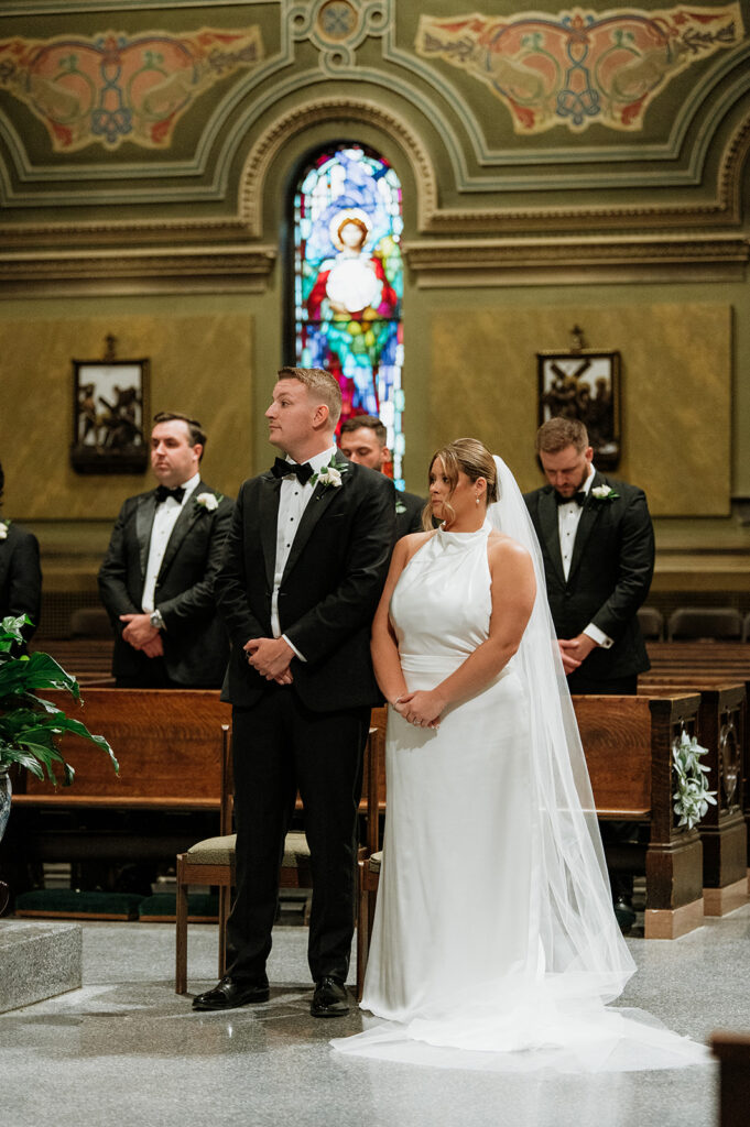 Bride and groom standing together at the altar during their Catholic wedding ceremony in Chicago.