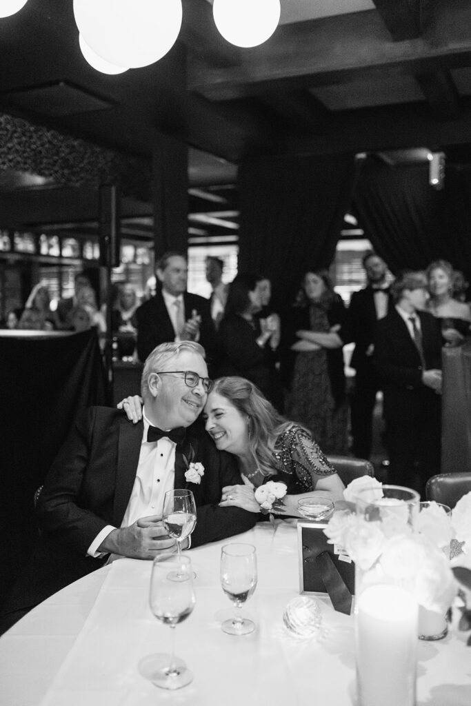 Black and white photo of guests laughing during a cocktail hour.