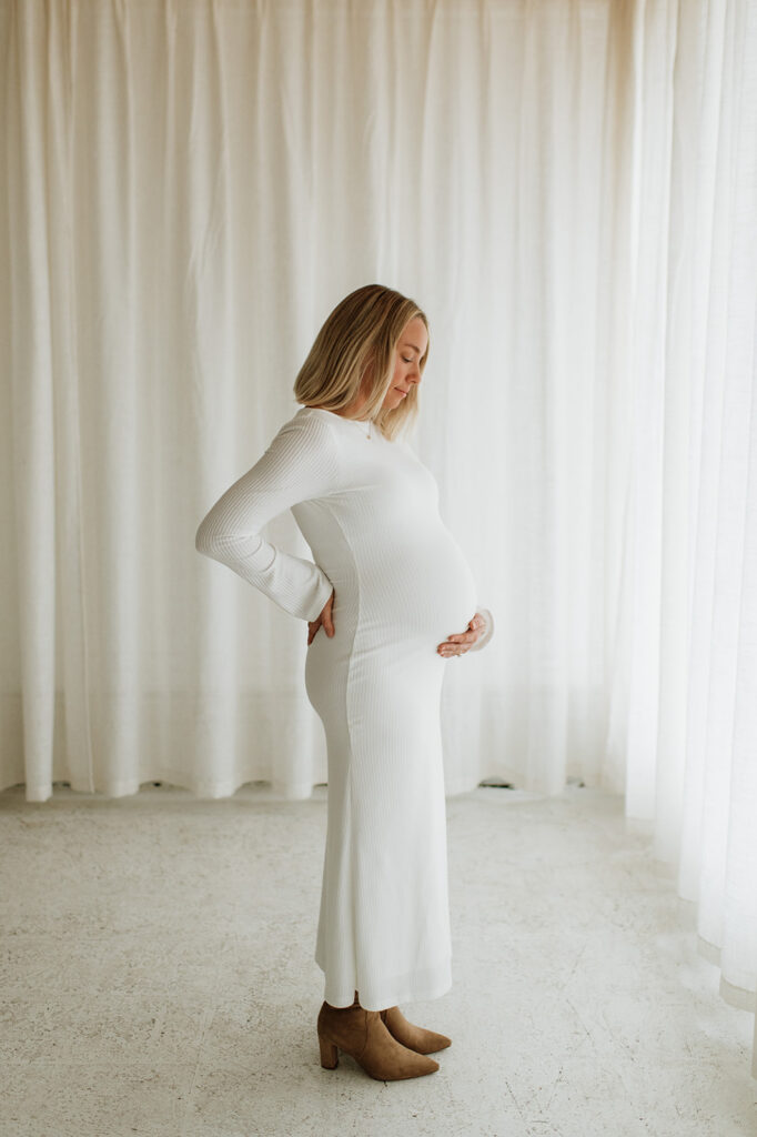 Pregnant woman looking down and holding her belly during South Bend Indiana maternity photos.