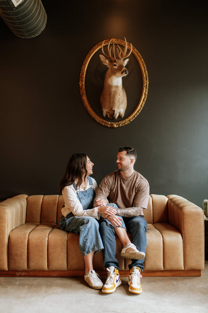Couple sitting on a couch during their antique shop engagement photos near South Bend, Indiana.