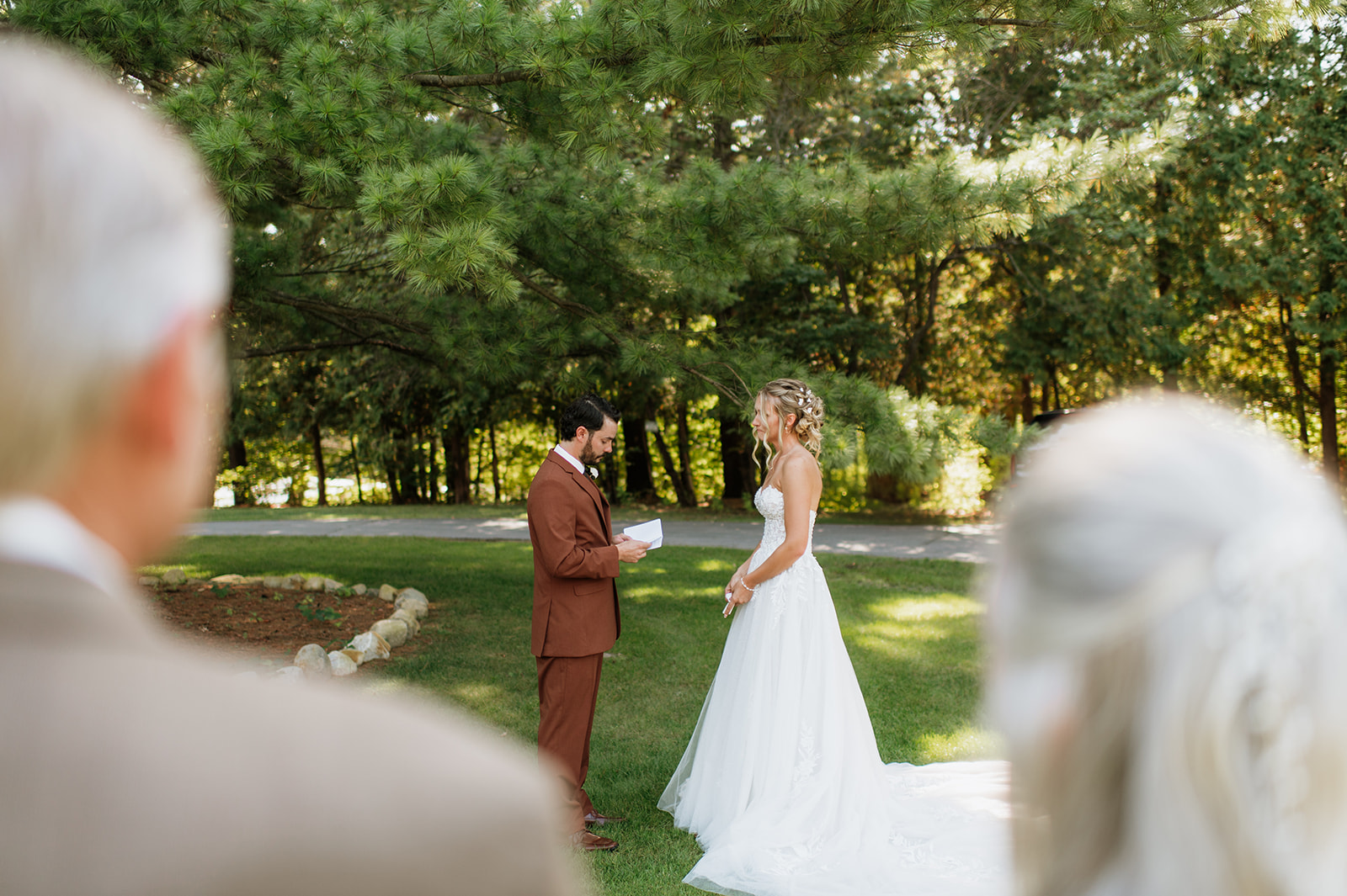 Family watching as the bride and groom exchange private vows outdoors. 