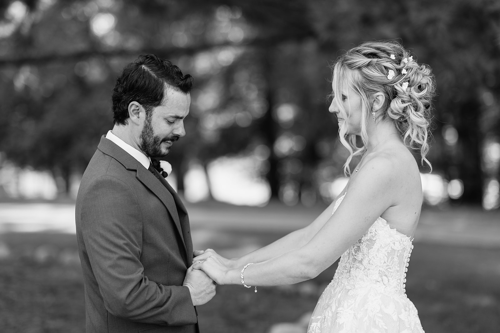 Bride and groom holding hands and sharing private vows during their first look at The Lodge at Rush Lakes.