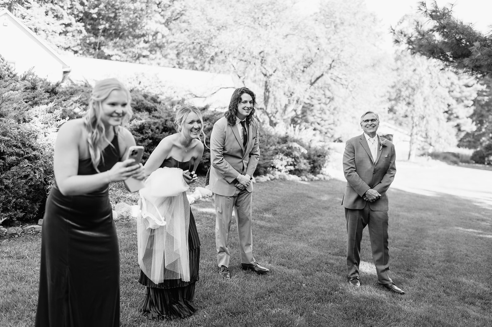 Black and white candid photo of guests watching the bride and groom exchange vows. 