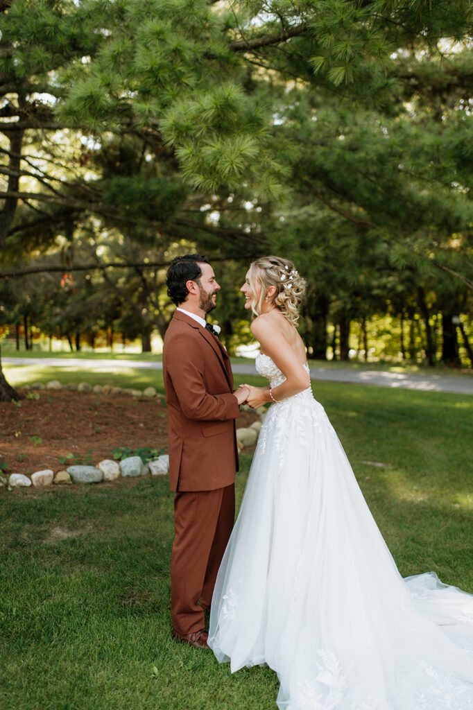 Bride and groom laughing together after their first look at The Lodge at Rush Lakes wedding in La Porte Indiana by Riley Trott Photography.