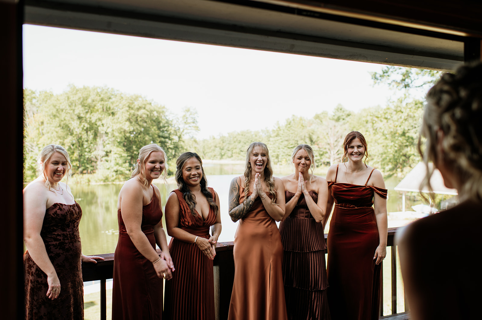 Bridesmaids reacting with excitement as they see the bride in her wedding dress at The Lodge at Rush Lakes in La Porte Indiana.