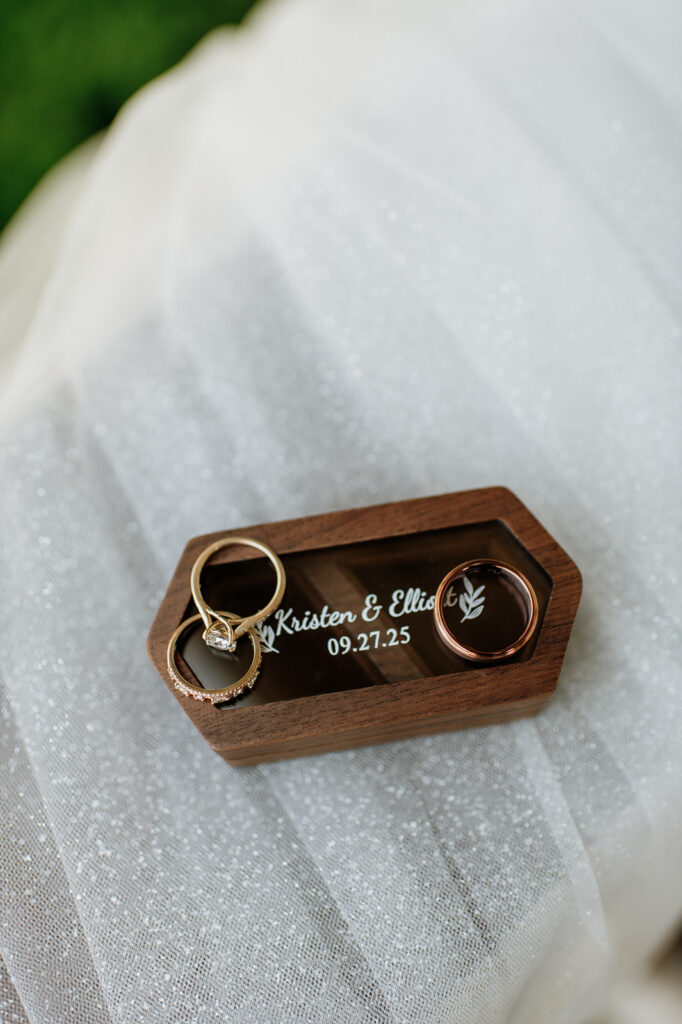 Wedding rings and band on a custom ring box.