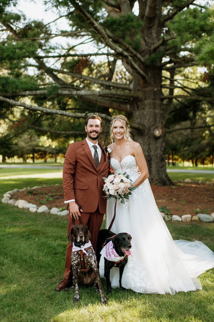 Bride and groom posing with their dogs at The Lodge at Rush Lakes.