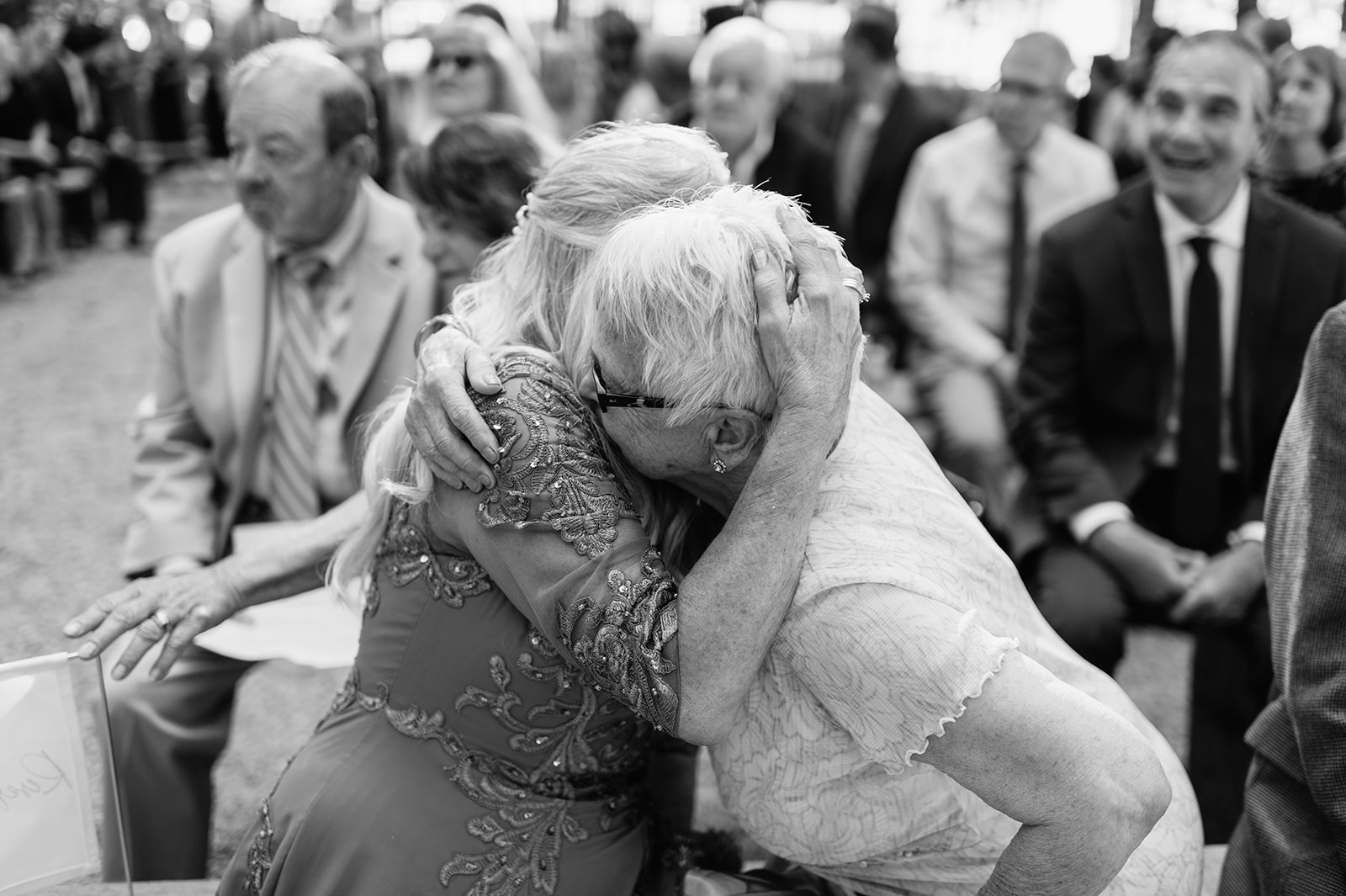 Black and white photo of family members hugging during the ceremony.