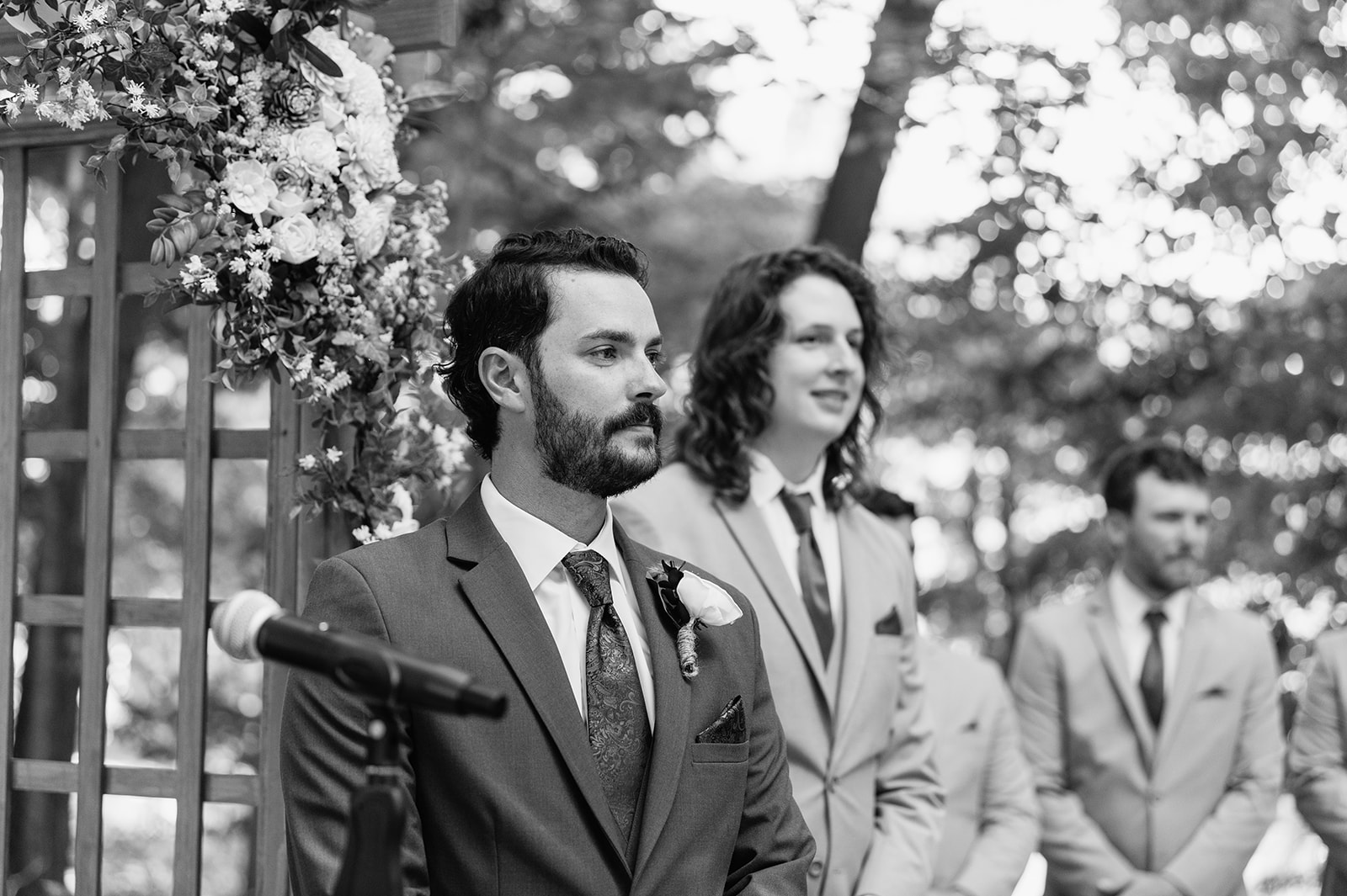 Groom standing with groomsmen during outdoor ceremony at The Lodge at Rush Lakes wedding.