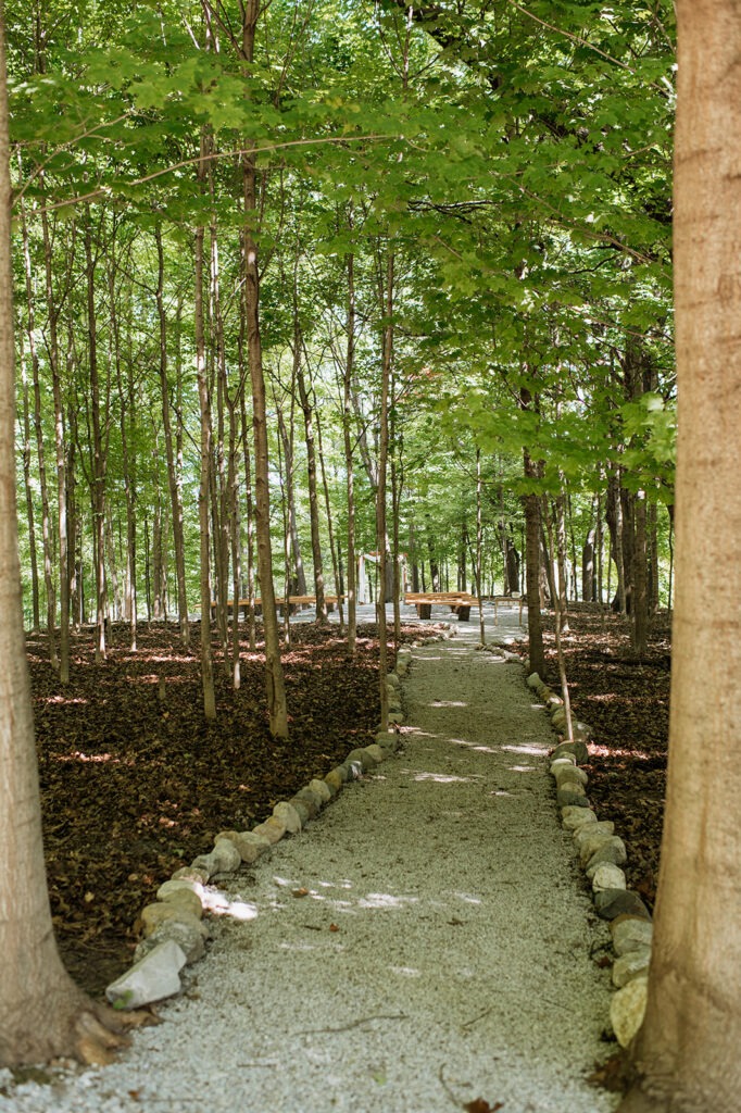 Wooded ceremony aisle leading to outdoor wedding ceremony space at The Lodge at Rush Lakes in La Porte Indiana.