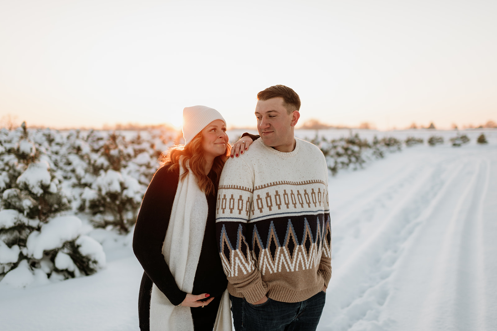 Couple posing during the sunset for their couples outdoor winter maternity photos in Northern Indiana. 