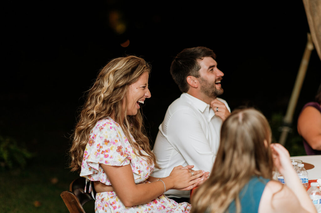 Guests laughing during speeches.