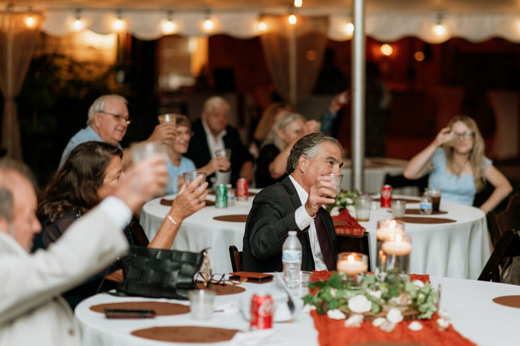 Guests raising their glasses during speeches.