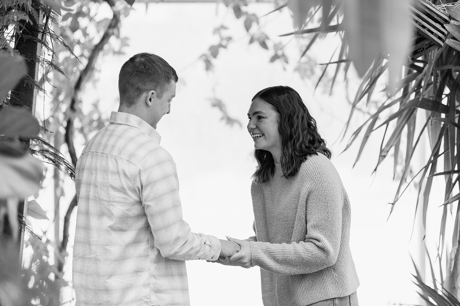 Joyful reaction after a South Bend Indiana surprise proposal captured in a bright indoor conservatory setting.