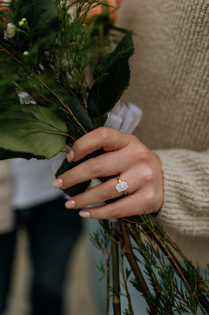 Close-up of engagement ring after a South Bend Indiana surprise proposal with bouquet details.