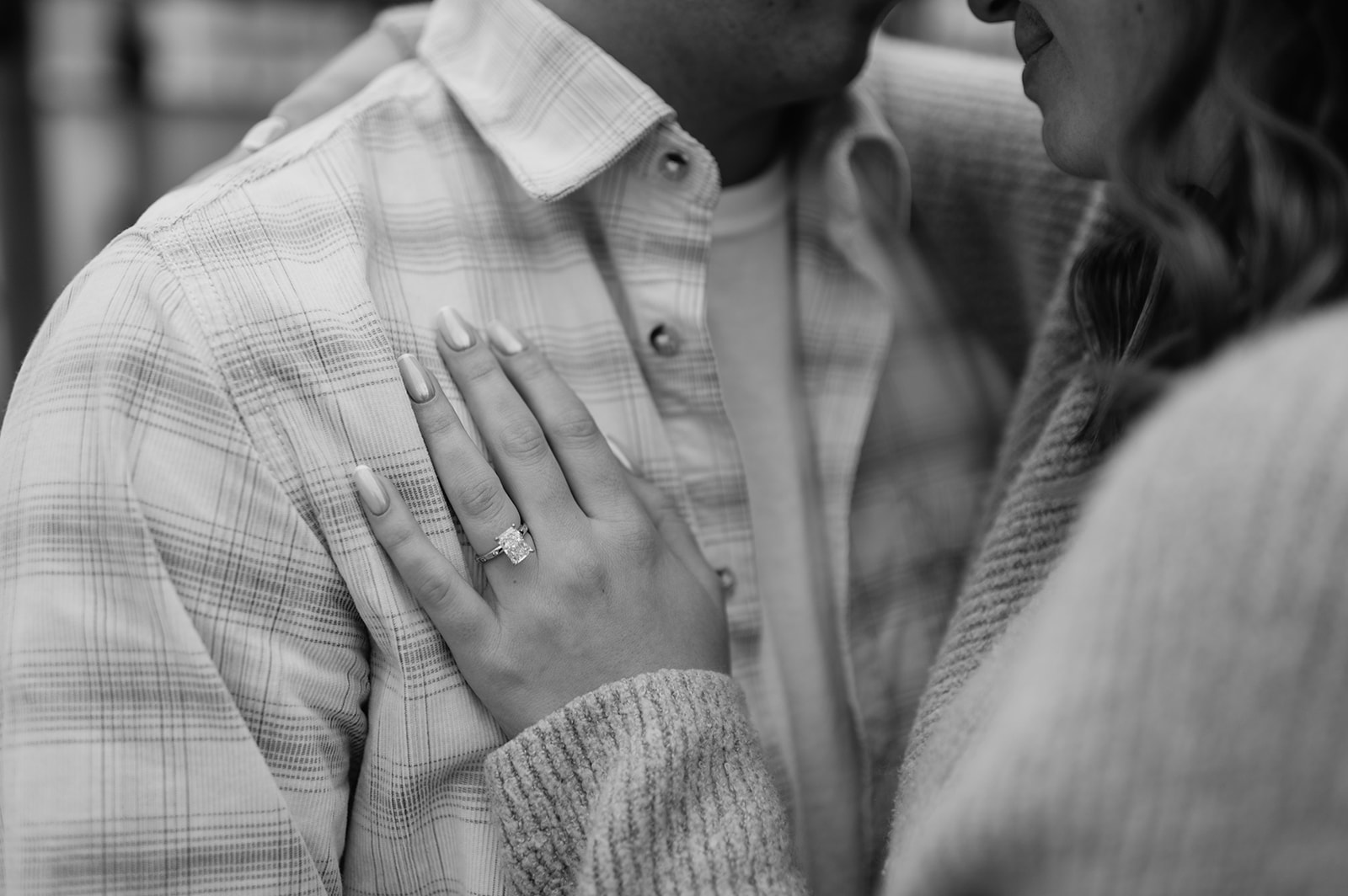 Black and white wide shot close-up of couple embracing after South Bend Indiana surprise proposal indoors.