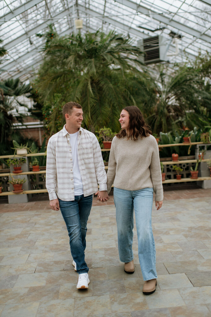 Couple walking together after South Bend Indiana surprise proposal inside Potawatomi Conservatories.