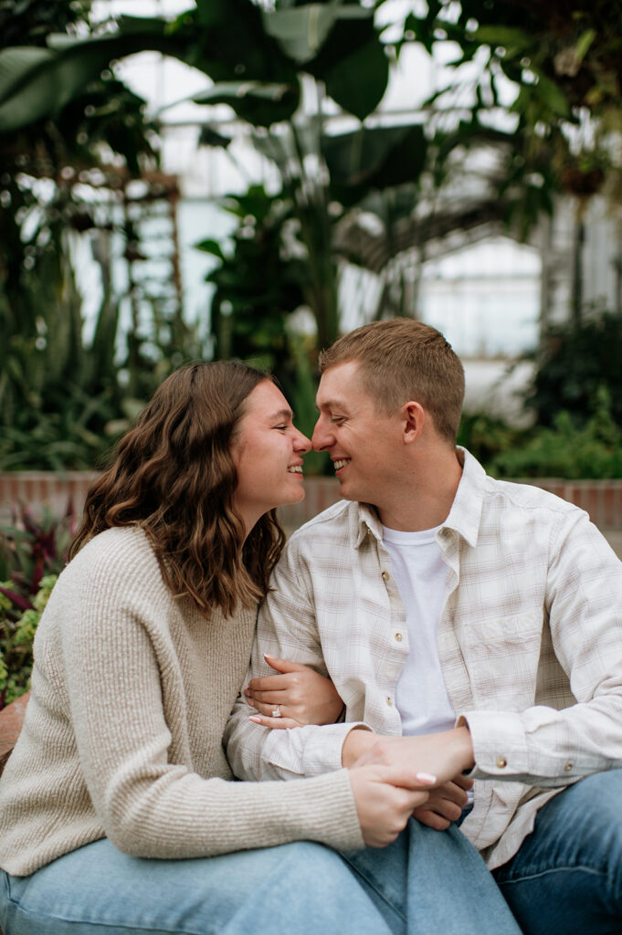 Couple touching noses while they pose for their proposal photoshoot indoors. 