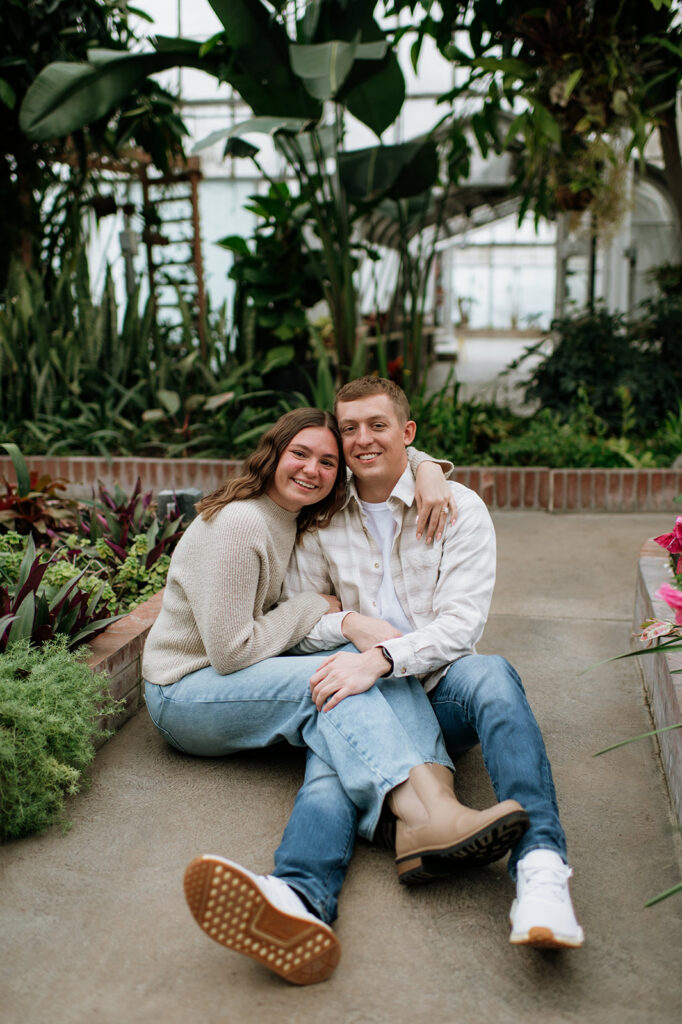 Couple sitting on the ground and hugging at Potawatomi Conservatories.