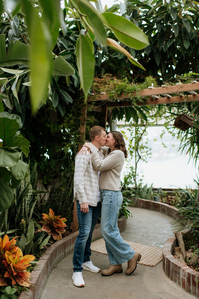 Couple kissing on a walkway at Potawatomi Conservatories.