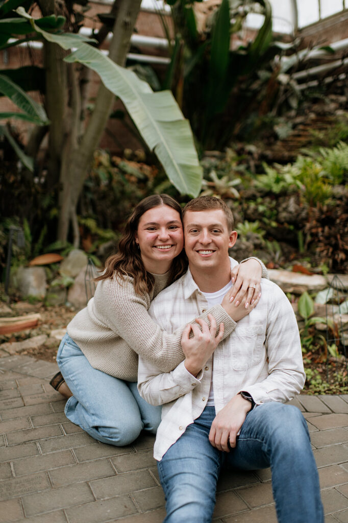 Couple posing for their surprise proposal photos at Potawatomi Conservatories.