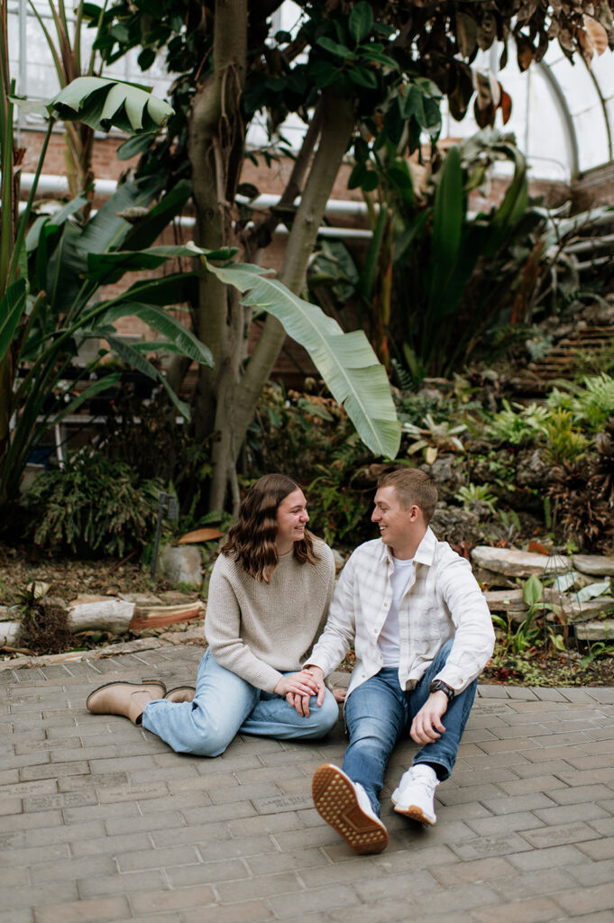 Couple sitting on the brick walkway at Potawatomi Conservatories.