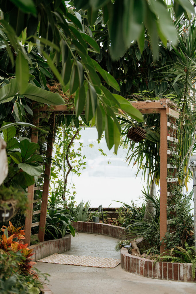  Potawatomi Conservatories with lush greenery and indoor garden walkway.