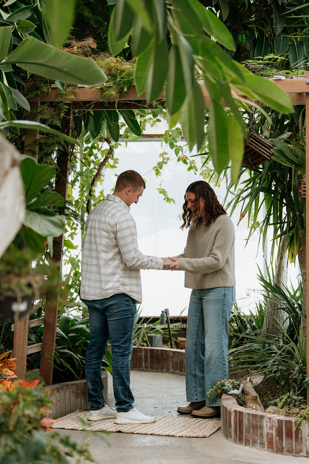 Woman smiling just before her partner proposes to her at Potawatomi Conservatories.