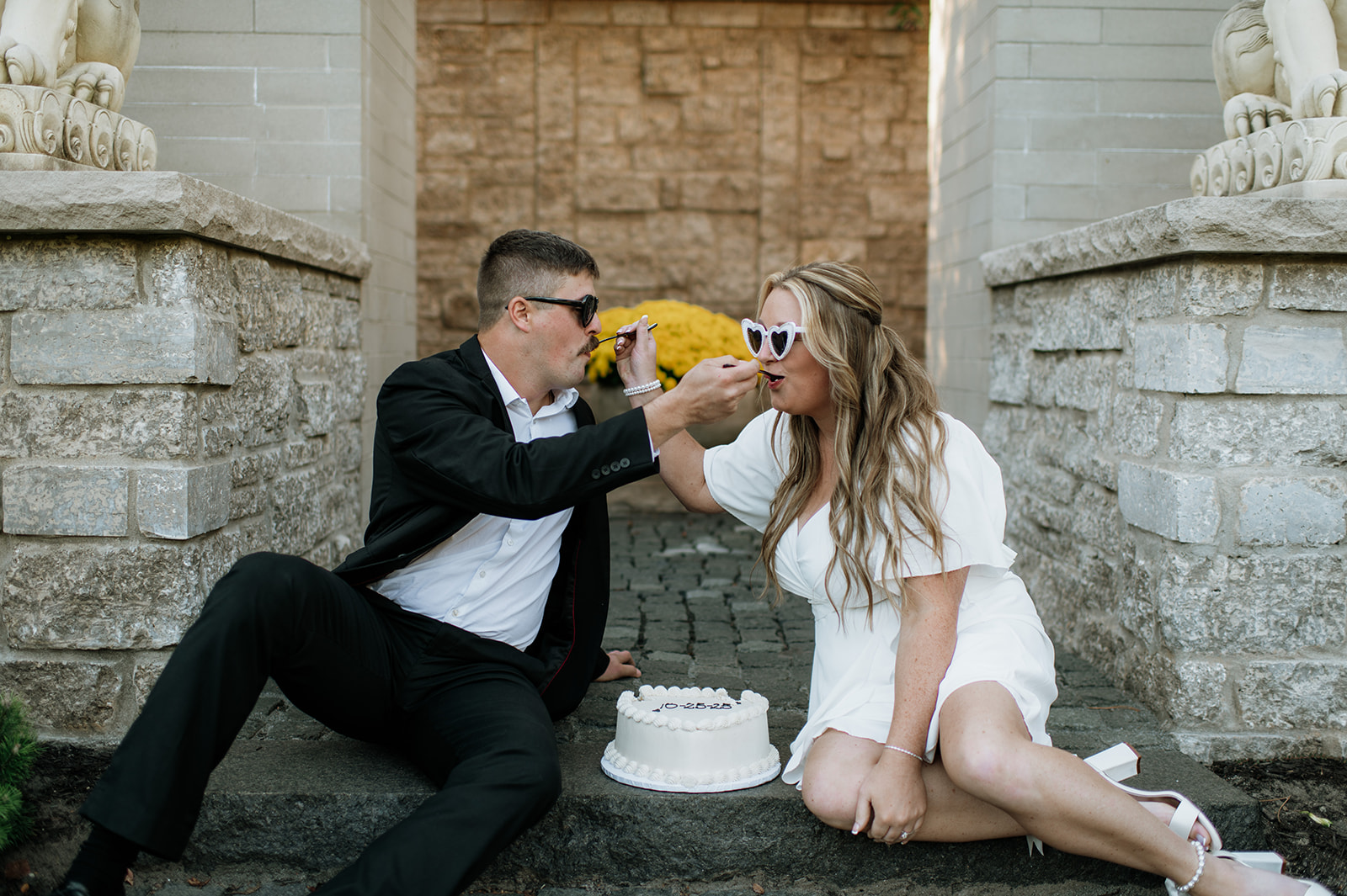 Couple feeding each other cake during their engagement session.