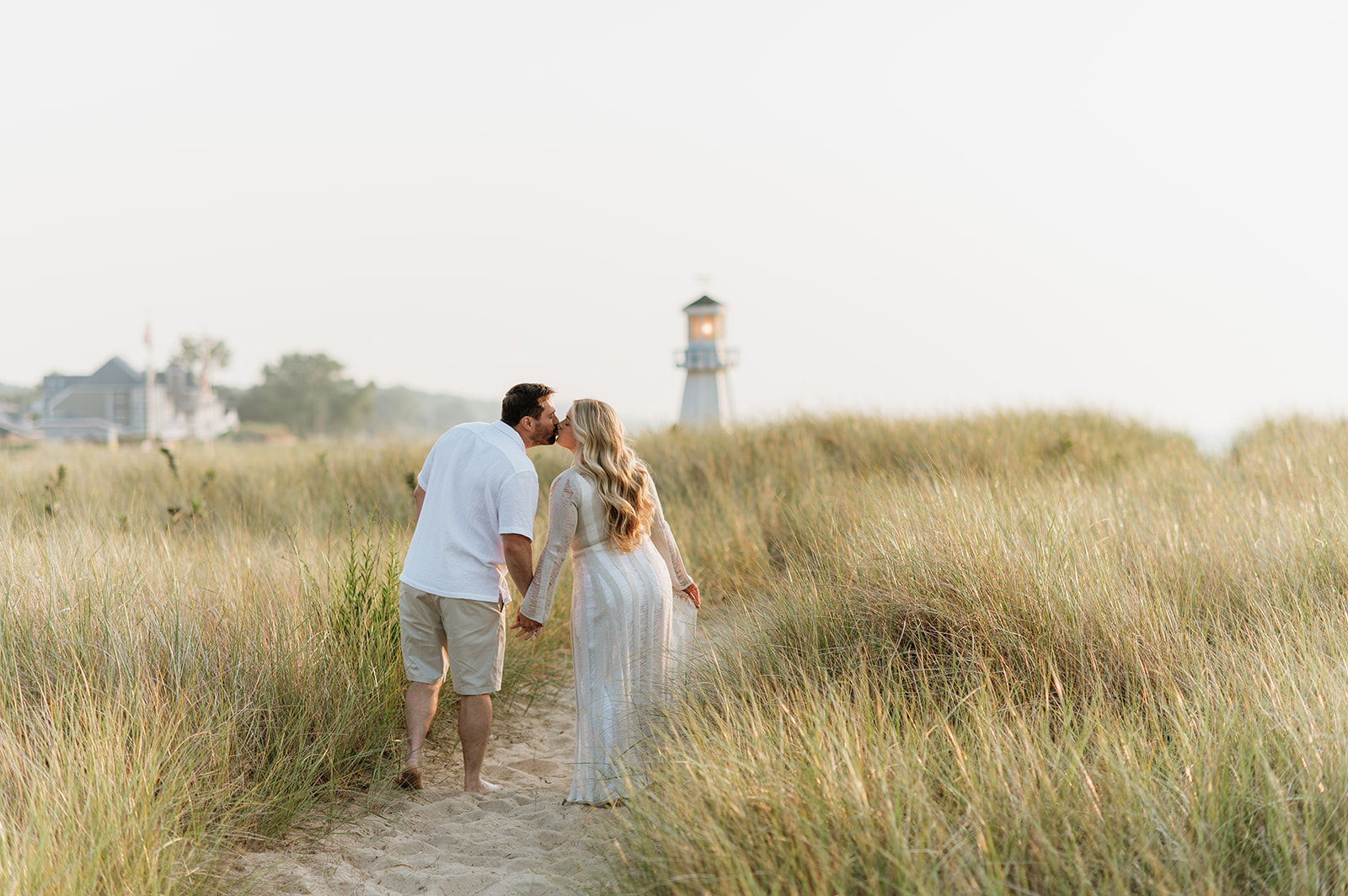 Couple walking along a beach path during their New Buffalo beach engagement photos.
