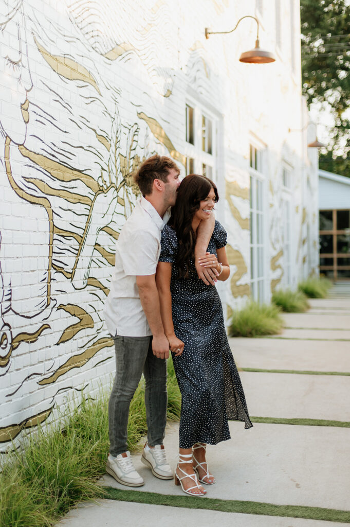Couple posing for engagement photos downtown.