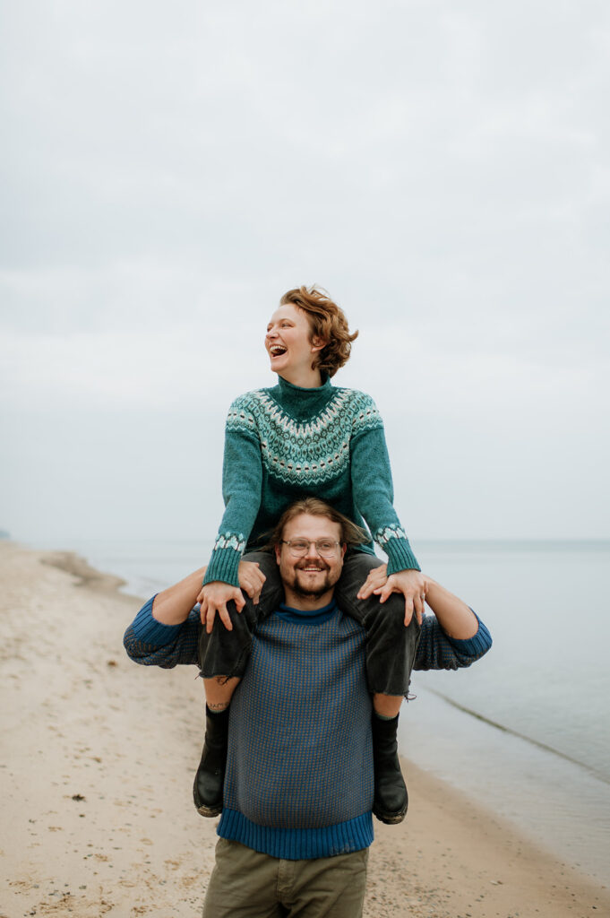Couple walking along the shoreline for their Lake Michigan engagement photos.