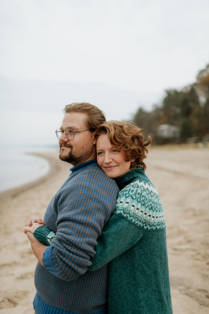 Couple posing on the shoreline of Lake Michigan for their engagement session.
