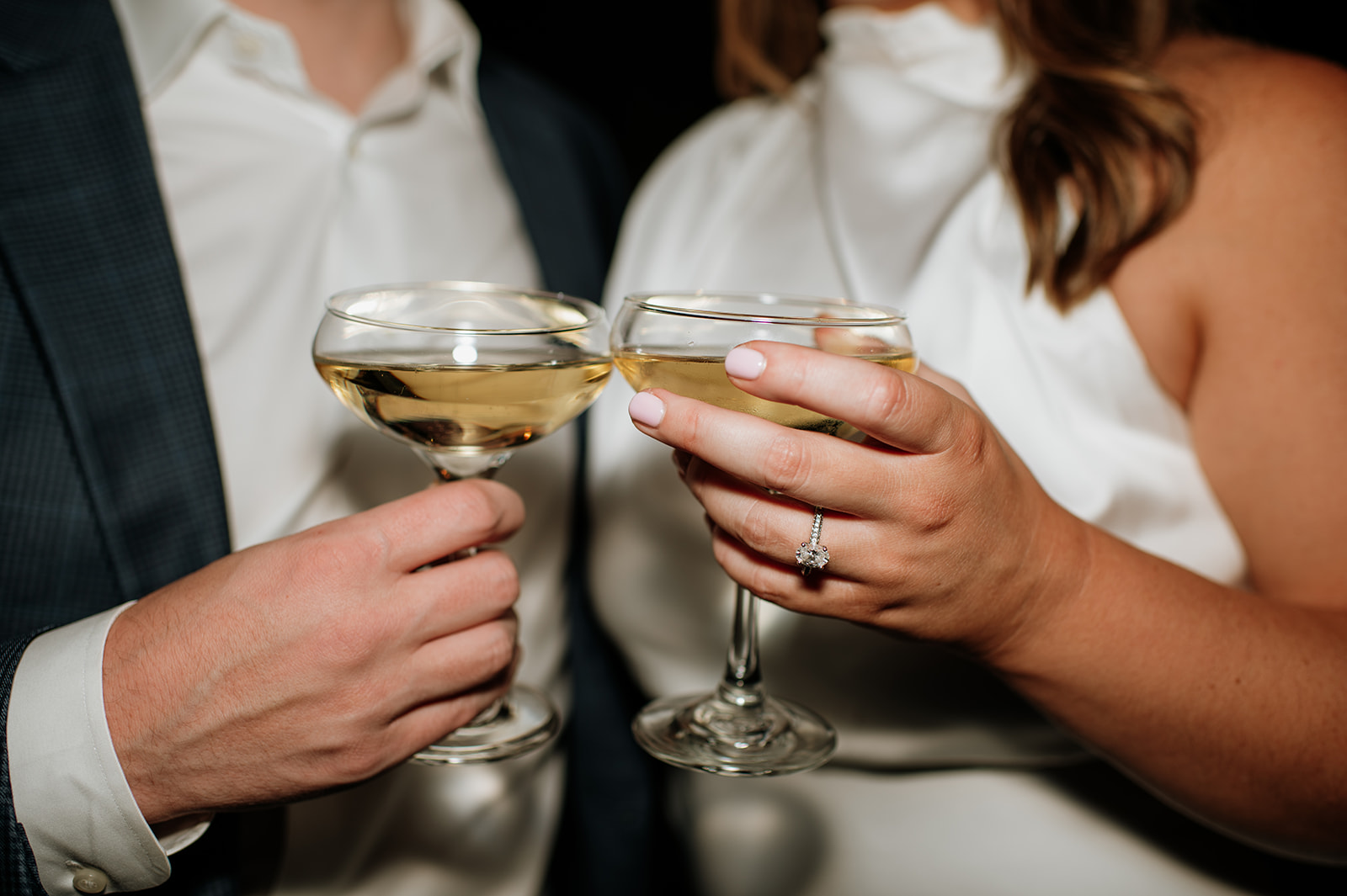 Flash engagement photo of a couple holding champagne.