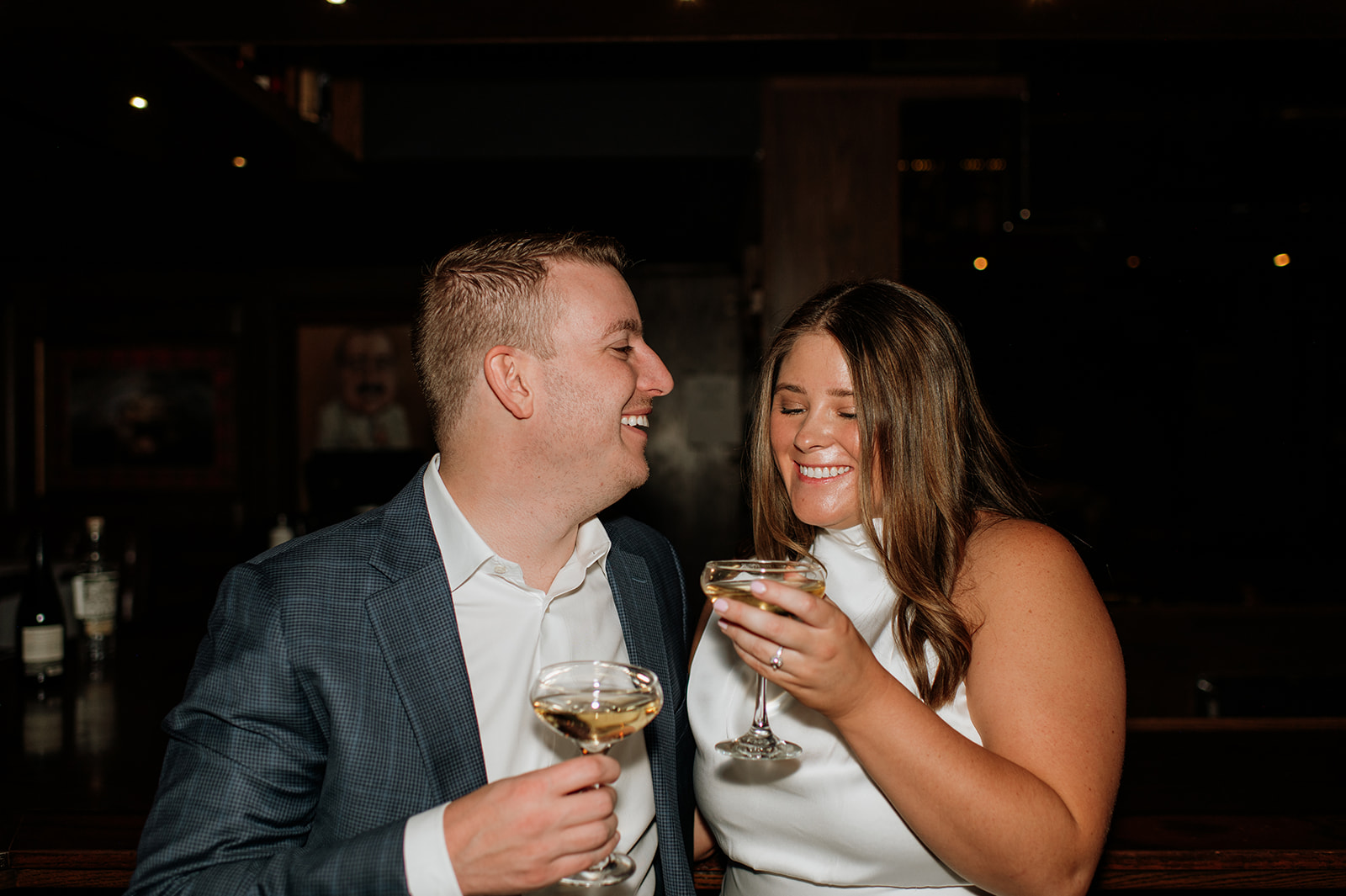 Flash engagement photo of a couple having drinks at a bar.