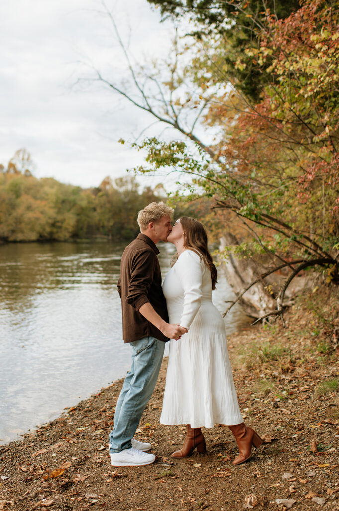 Couple kissing near the water.