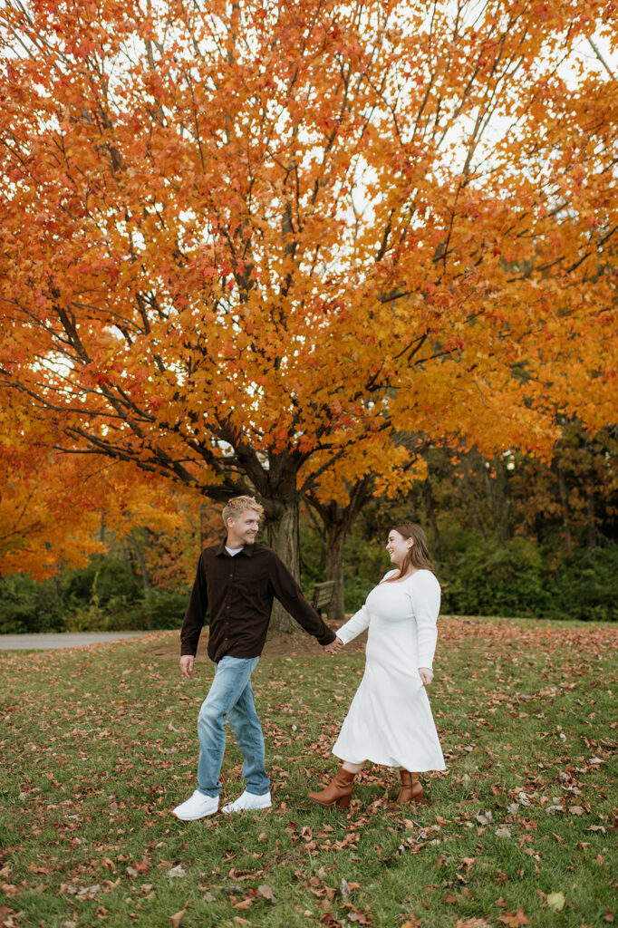 Couple walking hand in hand for their fall South Bend engagement photos at St. Patrick’s County Park.