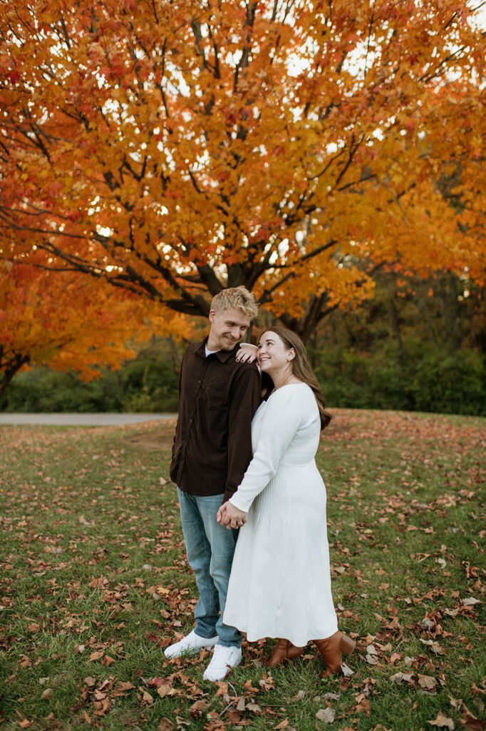 Couple smiling at one another during their outdoor fall South Bend engagement photos at St. Patrick’s County Park.