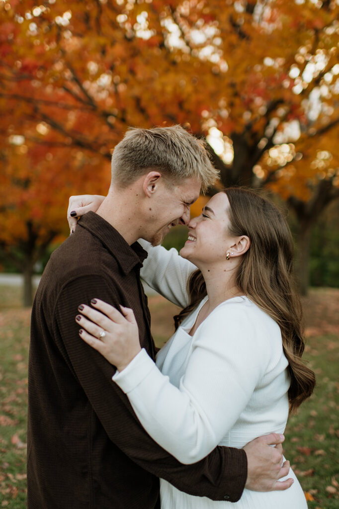 Couple smiling and touching noses during their outdoor fall engagement photos in South Bend, Indiana.