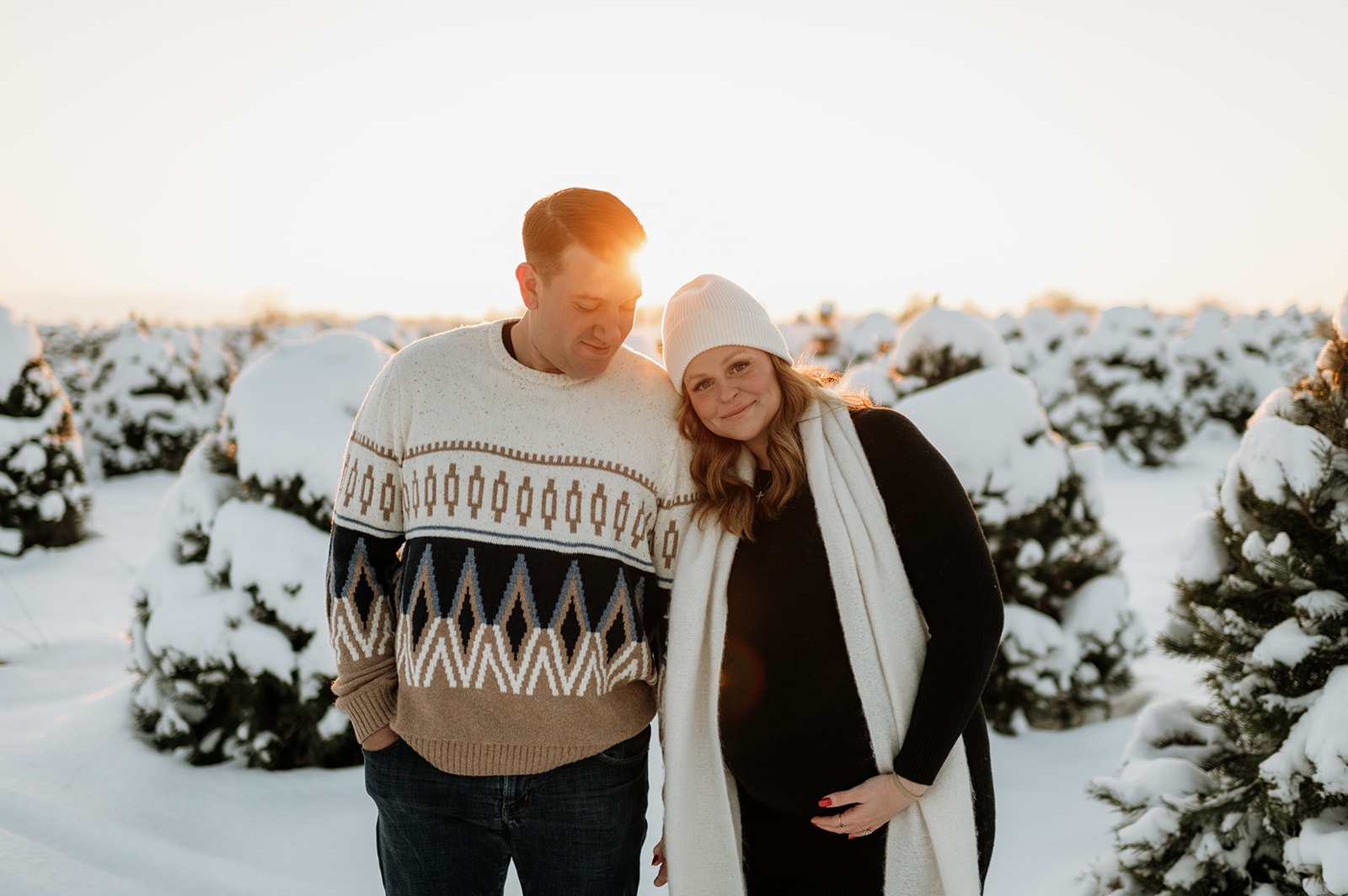 Couple posing for winter maternity photos at Flickinger Farms in Northern Indiana.