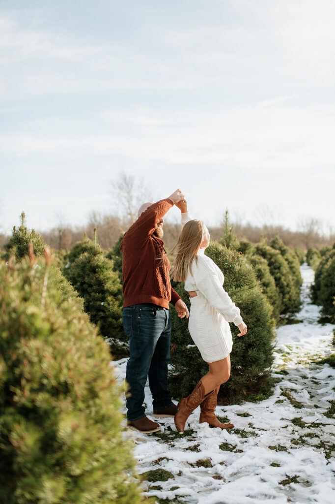 Man twirling his fiancé during their engagement photos at Flickinger Farms.